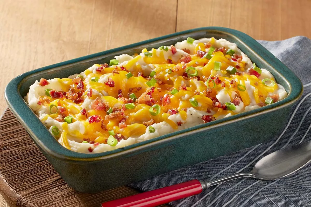 Cracker Barrel's Loaded Mashed Potatoes topped with melted cheese, crispy bacon, and green onions.