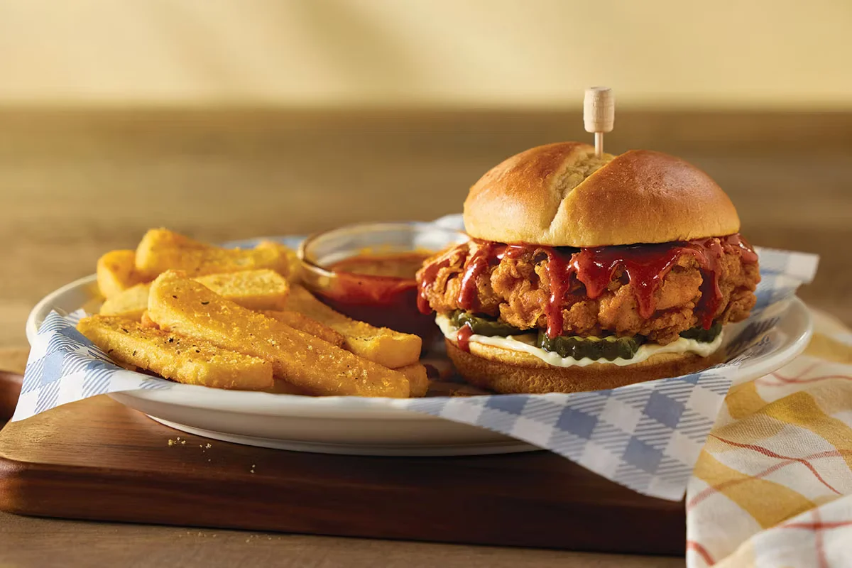 Signature Saucy Chicken Sandwich with crispy chicken, tangy sauce, and fresh toppings on a toasted bun.